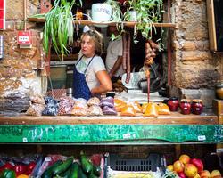 Photo by Yoav Aziz on Unsplash The image shows a person selling agri-food products through a small window that is decorated with plants.